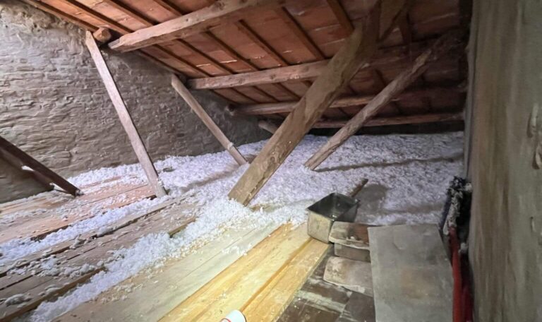 Sottotetto con travi in legno durante un cantiere di isolamento